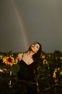 Beautiful young woman standing by flowering plants