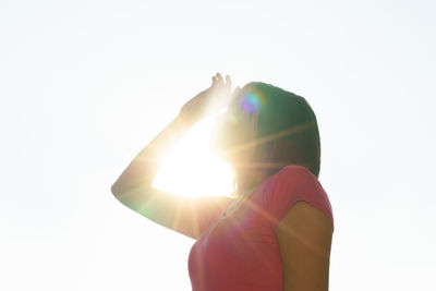 Midsection of woman holding sun against white background