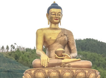 Low angle view of buddha statue against clear sky