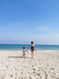 Rear view of boys standing on beach