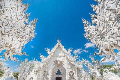 Low angle view of white building against blue sky