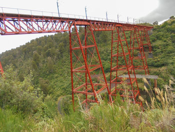 Metallic structure on bridge against sky