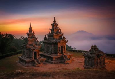 Temple against building during sunset