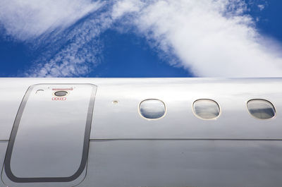 Fuselage of jet airplane against blue cloudy skies