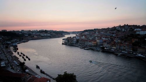 High angle view of river amidst buildings against sky during sunset