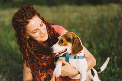 Beautiful woman plays with her jack russell dog in the park.