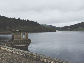 Built structure by lake against sky