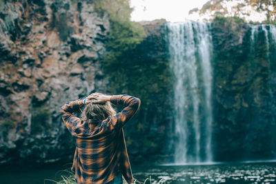 Rear view of woman looking at waterfall