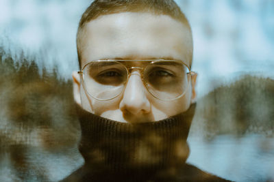 Close-up portrait of man covering mouth with turtleneck