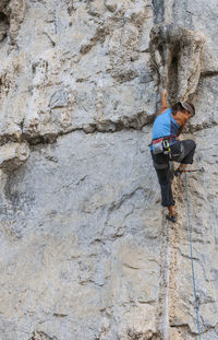 Woman climbing tuffa rock formation in yangshuo / china