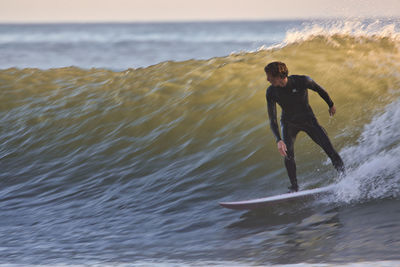 Full length of man surfing on sea shore