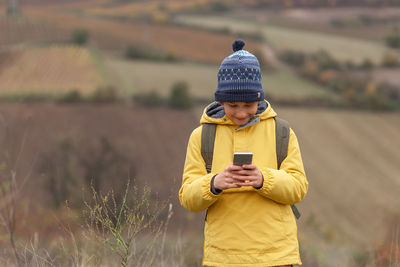 Man using mobile phone on field