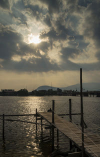 Pier on sea against sky during sunset