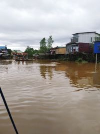 Scenic view of canal by buildings against sky