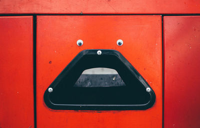 Anthropomorphic face on red trash can