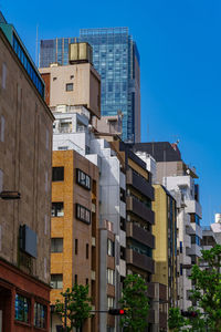 Low angle view of buildings against clear blue sky