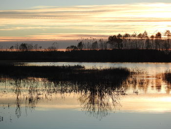 Scenic view of lake against sky at sunset