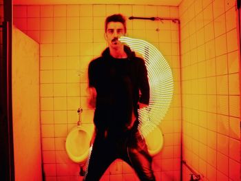 Full length of young man standing against wall