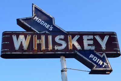 Low angle view of information sign against blue sky