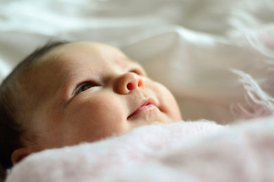 Close-up of baby sleeping on bed at home