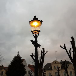 Low angle view of illuminated street light against sky