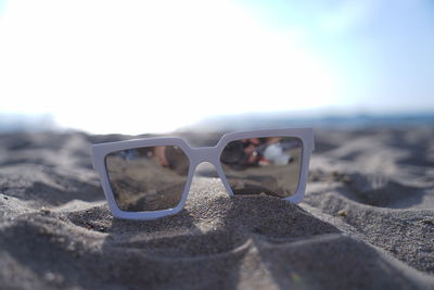 Close-up of sunglasses on beach