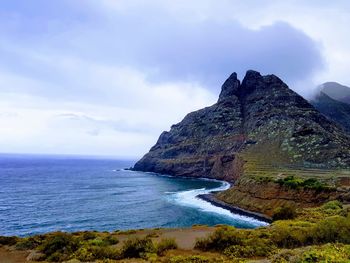 Scenic view of sea and mountains against sky