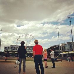 Group of people against cloudy sky