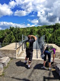 Full length of friends walking on mountain against sky