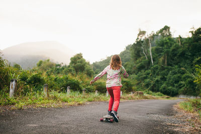 Full length of girl on tree against sky