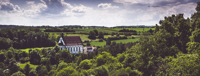 Panoramic view of trees and buildings against sky