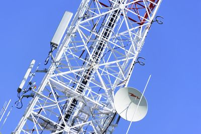 Low angle view of ferris wheel against clear blue sky