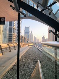 Railroad tracks by buildings in city against sky