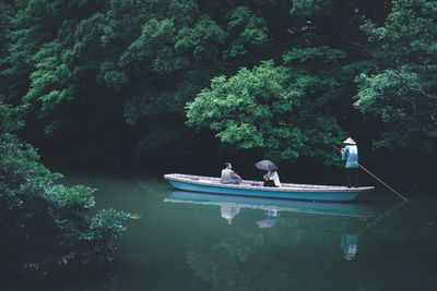 Boat sailing in lake by trees in forest