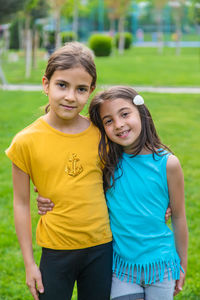 Portrait of smiling friends standing on field