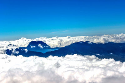 Scenic view of snowcapped mountains against blue sky