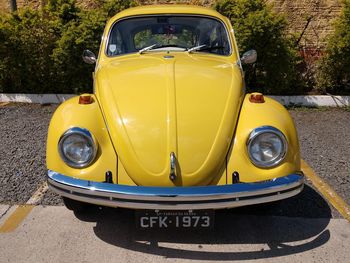 Close-up of yellow car on road