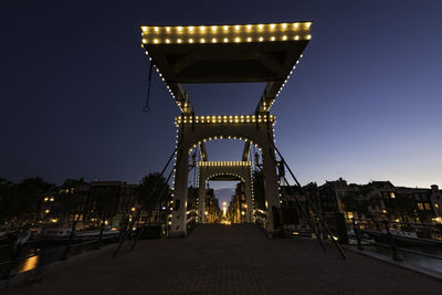 Illuminated bridge against sky at night