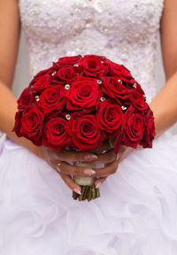 Close-up of woman holding red rose bouquet