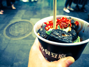 Close-up of hand holding ice cream in bowl