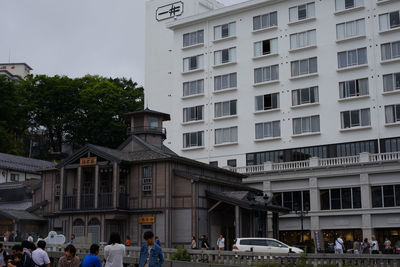 People on street against buildings in city