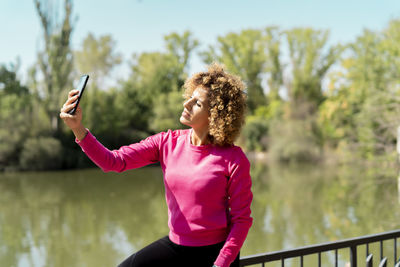 Sporty woman using her smartphone to take a selfie