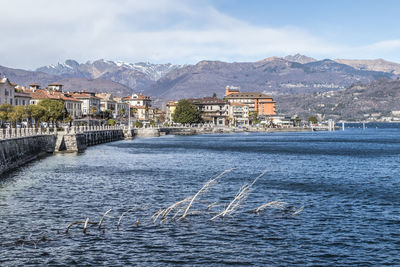 Scenic view of sea by townscape against sky