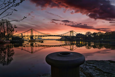 Bridge over river against sky during sunset