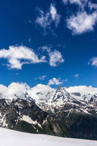 Scenic view of snowcapped mountains against blue sky