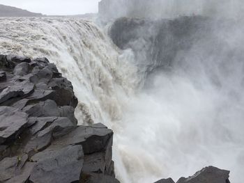 Scenic view of waterfall against sky