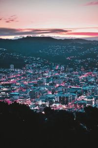 Aerial view of illuminated cityscape against sky at night