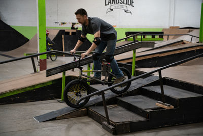 Side view of man working on bicycle