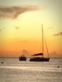 Boat sailing in sea at sunset