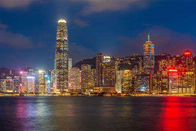 Illuminated buildings in city against sky at night